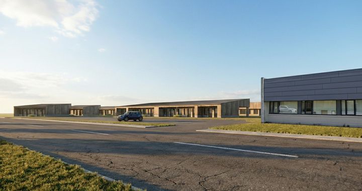 Visualisering af fremtidens Nørholm i sammenhæng med de eksisterende bygninger til højre i billedet.