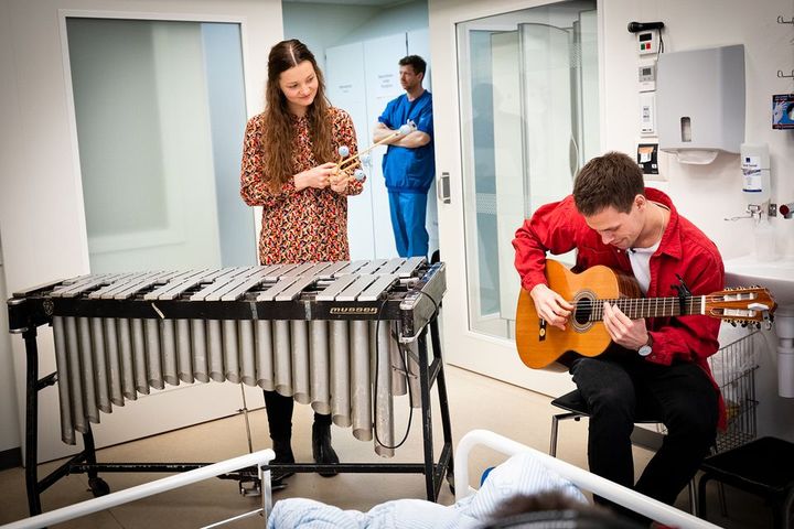 To personer spiller musik på en intensivafdeling.