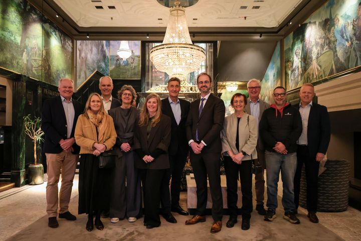 En gruppe mennesker samlet på et billede indenfor på et hotel