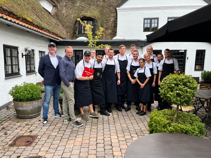 Karsten Bøttker, konceptchef i Dagrofa Foodservice (yderst tv.) og Stefan Nordahl Pedersen (står ved siden af Karsten), salgschef og medejer af HKI Ost, er i fuld sving med at aflevere de eftertragtede Michelin-plader til modtagerne. Her er de på besøg hos Søllerød Kro.