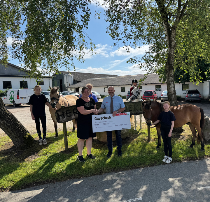 Herslev Rideklub har fået 10.000 kroner fra SPAR til ny pony. Pengene er en del af et lokalt initiativ om lokal støtte fra supermarkedskæden. Købmand Michael Winther fra SPAR Brejning overrækker checken.