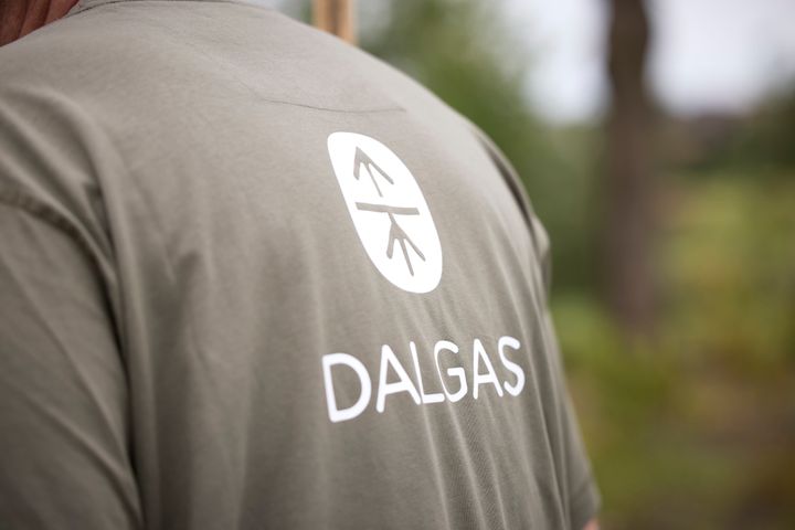 Mand i grøn T-shirt med teksten "DALGAS" og et logo på ryggen.