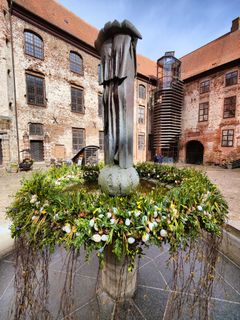 Medarbejdere og frivillige på Koldinghus pynter traditionen tro springvandet i Slotsgården, Fortuna, med blomster og grønt.