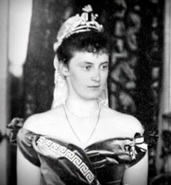 Forment tilbehør er fast del af Alexandrine kongelige garderobe. Ved hendes bryllup i 1898 bærer Alexandrine den diamantbesatte meanderbort. Indlån fra H.E. Grev Ingolf og Grevinde Sussie Hjorhøy af Rosenborg.