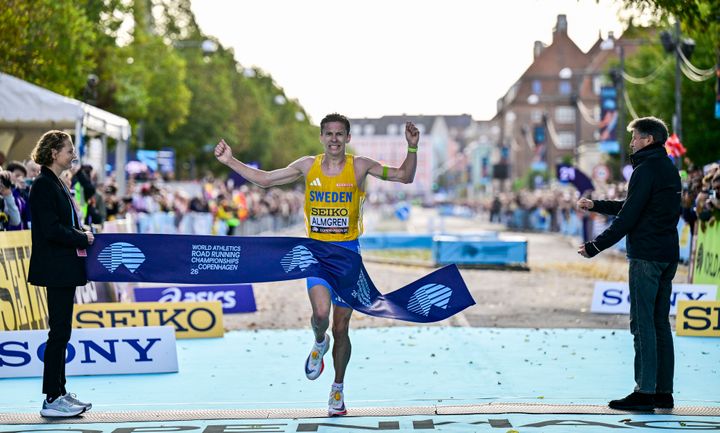 Vinder på VM halvmaraton, Andreas Almgren, krydser mållinjen, hvor Dorte Vibjerg og Sebastian Coe står klar med målbånd.