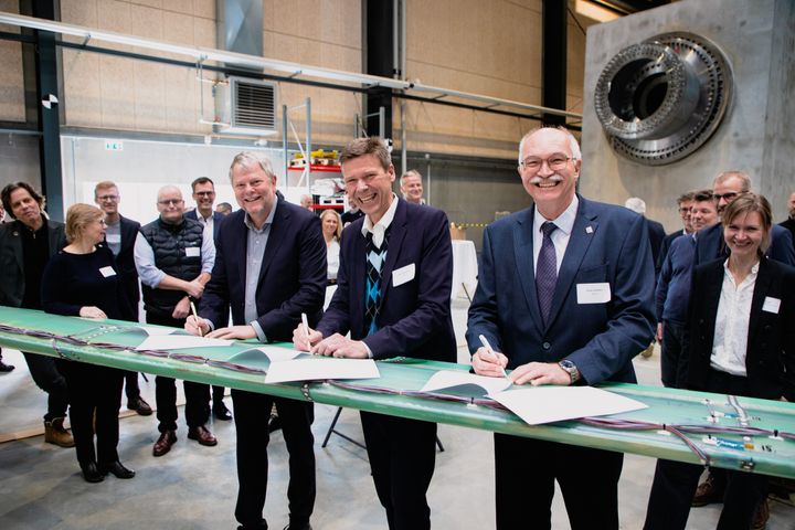På billedet ses Roskildes borgmester, Tomas Breddam, Andels CEO Jesper Hjulmand og DTU's rektor Anders Bjarklev. De er ved at underskrive en ny samarbejdsaftale på en vindmøllevinge.