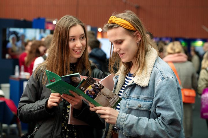 To potentielle studerende orienterer sig i en flyer til Åbent Hus-arrangement på DTU
