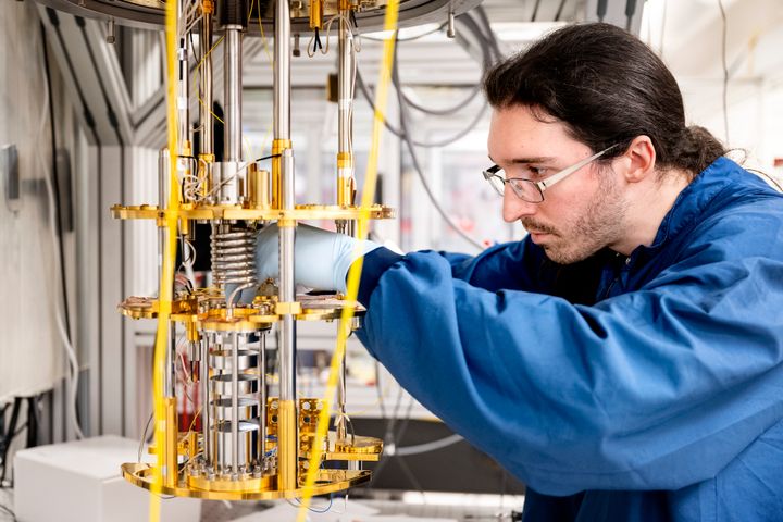 Forsker på DTU installerer elektronik i kvanteteknologisk apparat