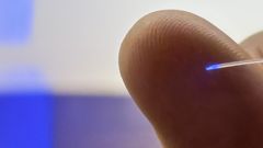 Et milimetertyndt hjerneimplantat foran en pegefinger. Foto: Peter Aagaard Brixen