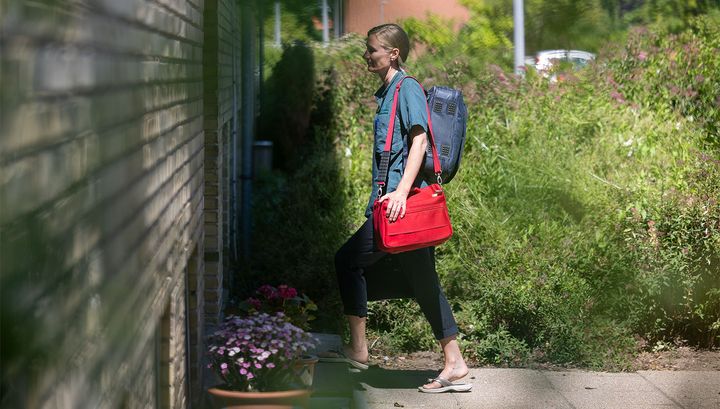 Sygeplejerske er på vej hjem til en borger for yde hospitalsbehandling i eget hjem.