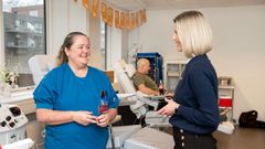 Sygeplejerske Linda Mikkelsen og sygefaglige direktør, Rikke Petersen Ravn med den første plasmadonor i baggrunden.