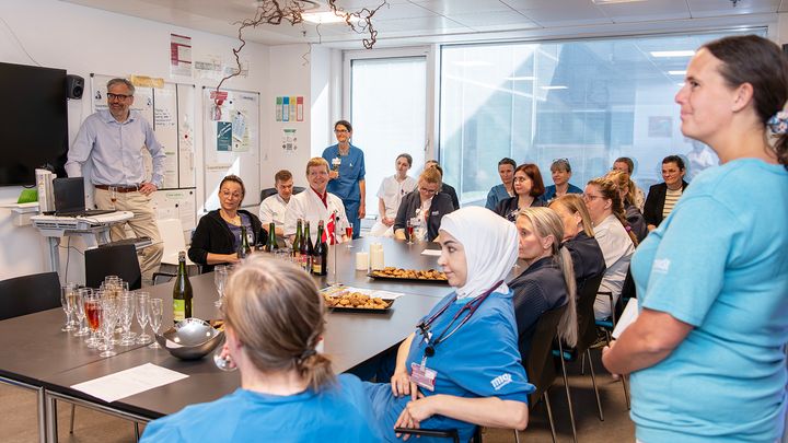 Medarbejdere fra Akutafdelingen mødes og fejrer en flot inspektorrapport med kage og bobler