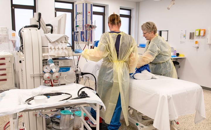 Billedet viser en operationsstue, hvor to sundhedsfaglige medarbejdere er ved at klargøre en patient til en kikkertundersøgelse