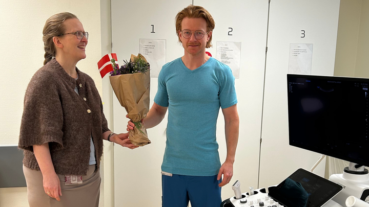 Cheflæge Berit Gosvig overrækker en fin buket til Søren Damsted i anerkendelse af den flotte eksamen.