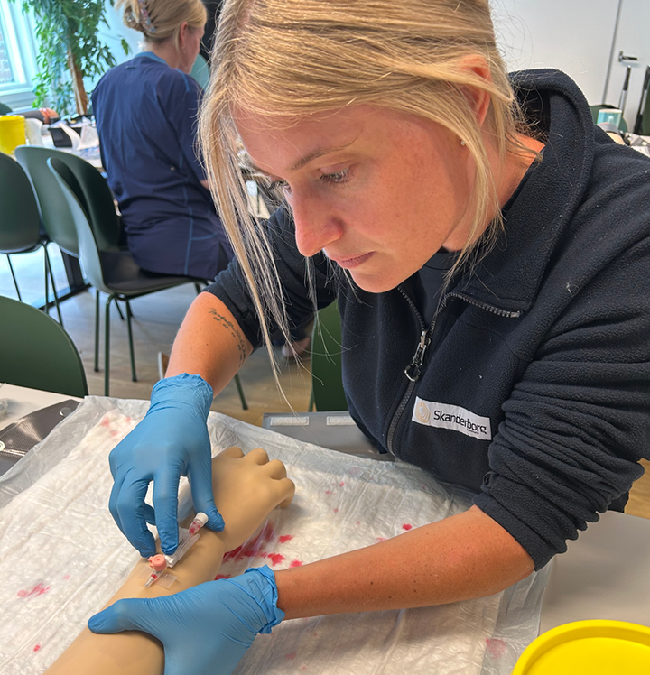 Sygeplejerske Camilla Snorgaard øver sig i at lægge en venflon på en test-arm.