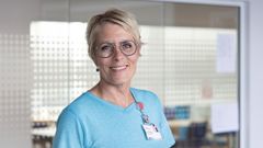 Billede af kvinde i blå t-shirt med navneskilt.