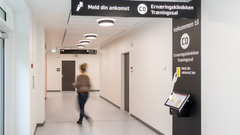 En gang i en klinik med skilte for "Ernæringsklinikken Træningssal" og en person, der går.