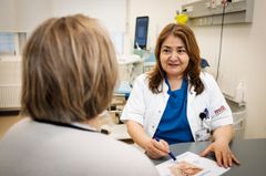 Kvindelig læge i samtale med anden kvinde