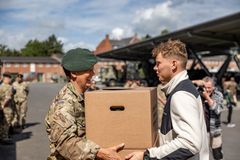 Civil leverer papkasse med uniform til Forsvaret
