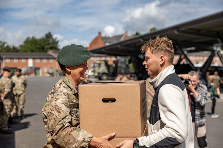 Civil leverer papkasse med uniform til Forsvaret