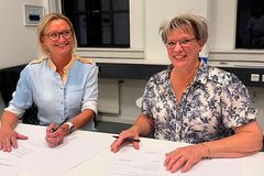 Formand for Danske Fysioterapeuter, Jeanette Præstegaard og forperson for Fysioterapeuternes Arbejdsgiverforening, Tina Rank Franzen underskriver her overenskomstaftalen.