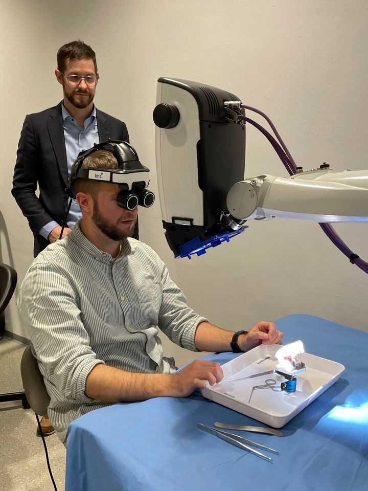Projektleder Steven Andersen har head mounted-display på og visualiserer en 3D-printet øremodel gennem RoboticScope fra BHS Technologies. Projektpartner Daniel Sieber, MCI Innsbruck i baggrunden.