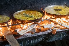 Paella tilberedes over åben ild.