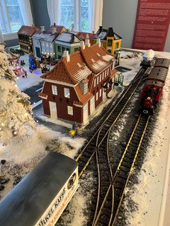 Et elektrisk juletog kører gennem Dansk Modelbane Forenings julebord. Tryk på en knap, så kører toget en tur i det magiske julelandskab.