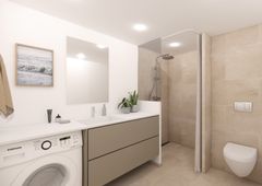 Badeværelse med vaskemaskine, moderne brusekabine, toilet, og stort spejl over en vask med dobbeltrum.
