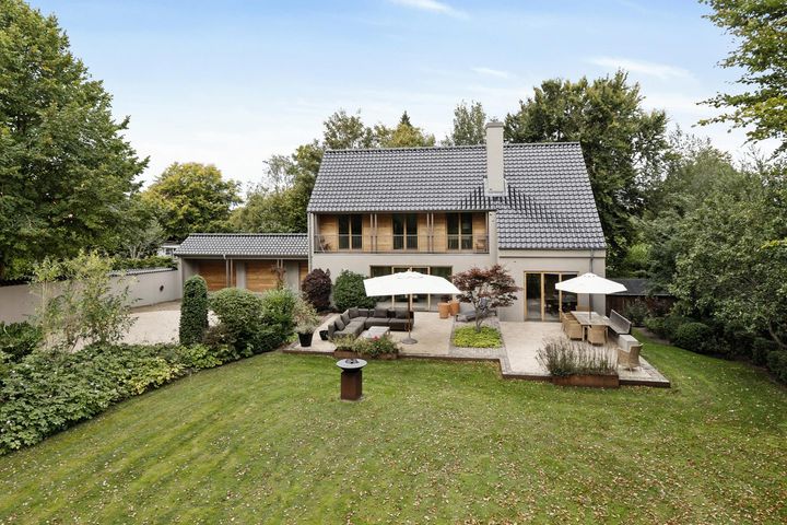 Moderne hus med stor terrasse og grøn have.