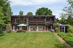 Moderne to-etagers hus med stor have og træterrasse.