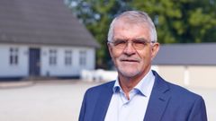 Berg Risager er mægler i Nybolig Landbrug. Det er han på billedet her iklædt jakkesæt stående foran med et stuehus.
