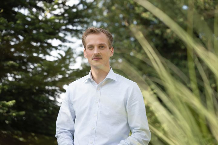 Billedet viser Christian Ohrtmann, formand for LandboUngdom i hvid skjorte i en have.