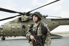 Kvindelig soldat fra Flyverhjemmeværnet bevogter en af Forsvarets helikoptere.