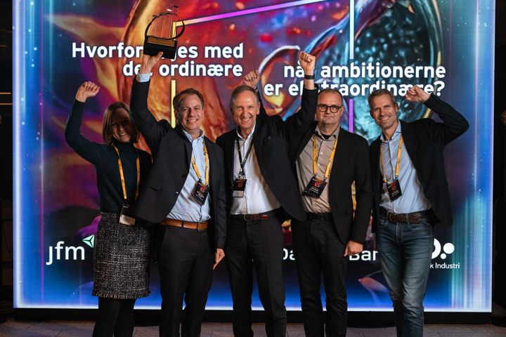 En glad Carsten Haagen Nielsen løfter trofæet over hovedet sammen med holdet af glade vindere fra Minerva Imaging