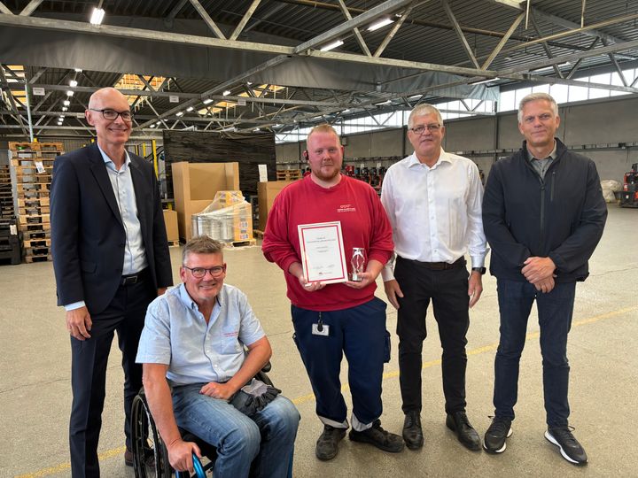 En glad, nyuddannet chauffør bliver hyldet. Fra venstre er det branchedirektør i ATL, Lars William Wesch, adm. direktør i Peder Olsen & Søn, Henrik Olsen, godschauffør Mikkel Gregersen, driftsdirektør i Peder Olsen & Søn, Michael Mertov og afdelingslederleder Syddansk Erhvervsskole, Magnus Frøstrup Nørregaard. Foto: ATL – Transportens Arbejdsgivere.