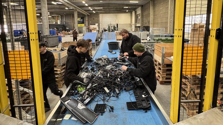 Medarbejdere, der sorterer elektorik på et bånd