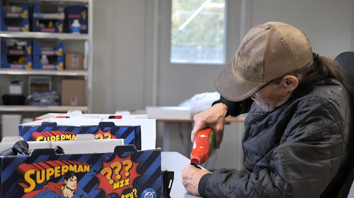 Mand hælder noget i en mindre beholder