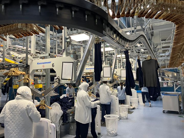 Mennesker, der arbejder i vaskeriet Textilia Aalborg.