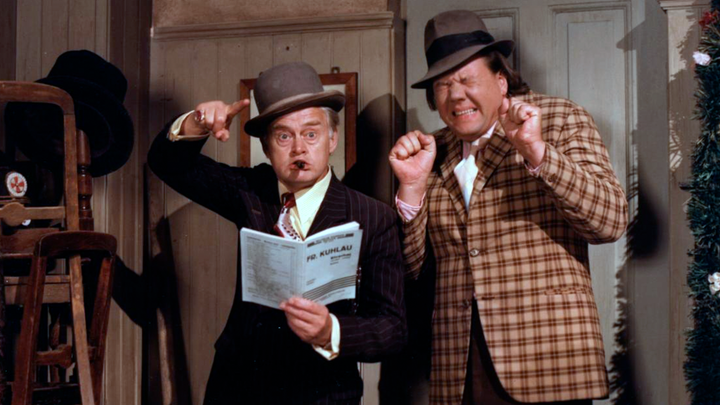 I ’Olsen Banden ser rødt’ er en uforglemmelig scene, hvor Egon, Benny og Kjeld forsøger at føre en af Egons mange planer ud i livet i takt til musikken på Det Kongelige Teater.
