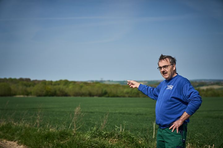 Landmand peger på hans mark og hans skov