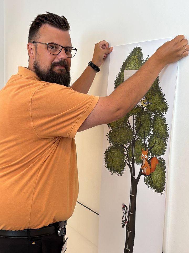 foto af mand der hænger plakat op på sygehuset