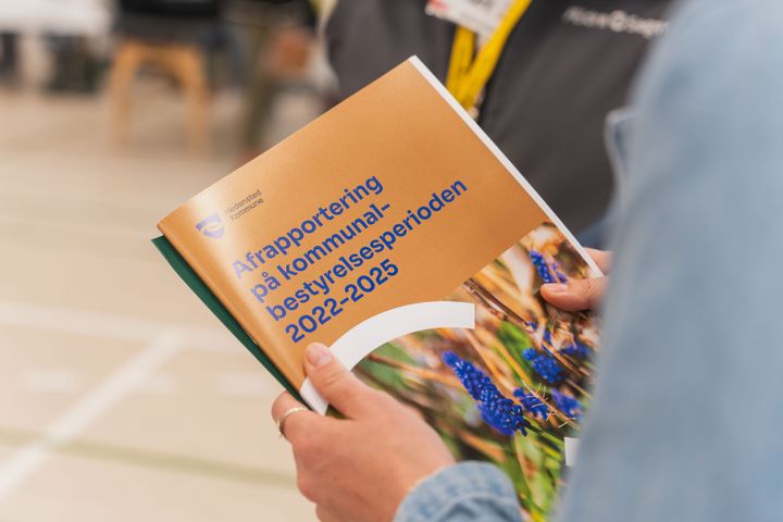 På billedet ses en rapport med titlen: "Afrapportering på kommunalbestyrelsesperioden 2022-2025.