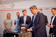 Den bayerske statsministeren Dr. Markus Söder (i forgrunnen) signerer en batteripakke fra MAN Nürnberg-nettstedet. Til stede var også to MAN-ansatte og Nürnberg-ordfører Marcus König, Ulrich Zimmer og Arno Puls fra MAN Truck & Bus (fra venstre).