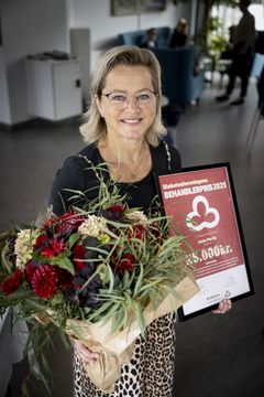Sygeplejerske Janie Parris med blomster og Årets Behandlerpris 2025