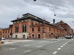 HOFORs 125 år gamle forsyningsbygning med røde mursten og buede vinduer og Prinsessetårn, hvor lyset brænder året rundt.