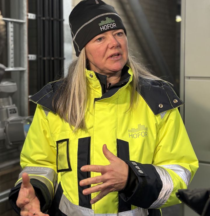 Mette Kyed, driftschef for fjernvarme i HOFOR, står foran en varmepumpe og fortæller, hvordan kulden får københavnerne til at skrue op for varmen, og at det har givet det højeste varmeforbrug i fem år.