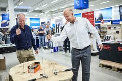 Salgsdirektør Peter von der Hude (th), der har ansvar for Ahlsells butikker, dyster med butikssalgschef Anders Paludan Ekdahl om at slå søm i en træstub til åbningen af Ahlsells håndværkerbutik i Vallensbæk. Når Milwaukees røde værktøjstruck kommer forbi butikken, bliver det med en hel del mere avanceret grej end en hammer.