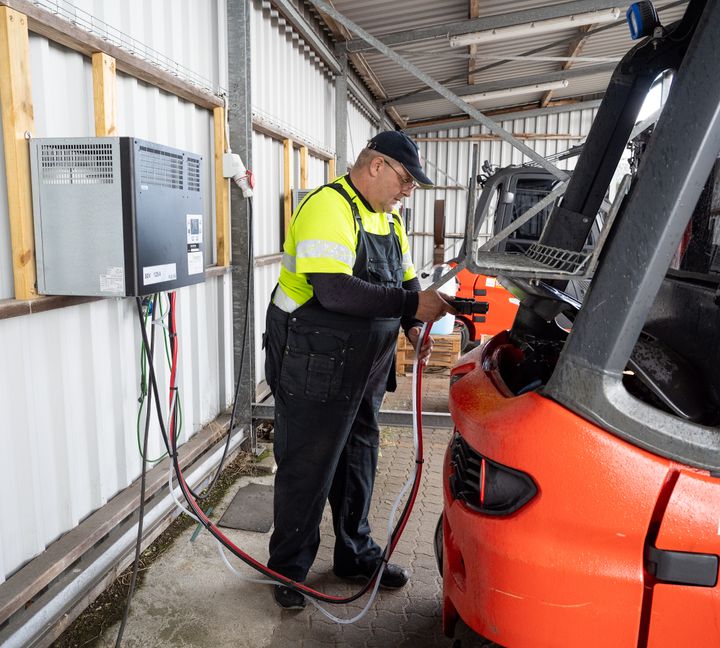 En elektrisk truck lades på Ahlsells logistikcenter i Billund, hvor al intern transport nu kører på el.