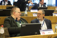 To mænd sidder ved et bord og taler under et møde i Bruxelles.